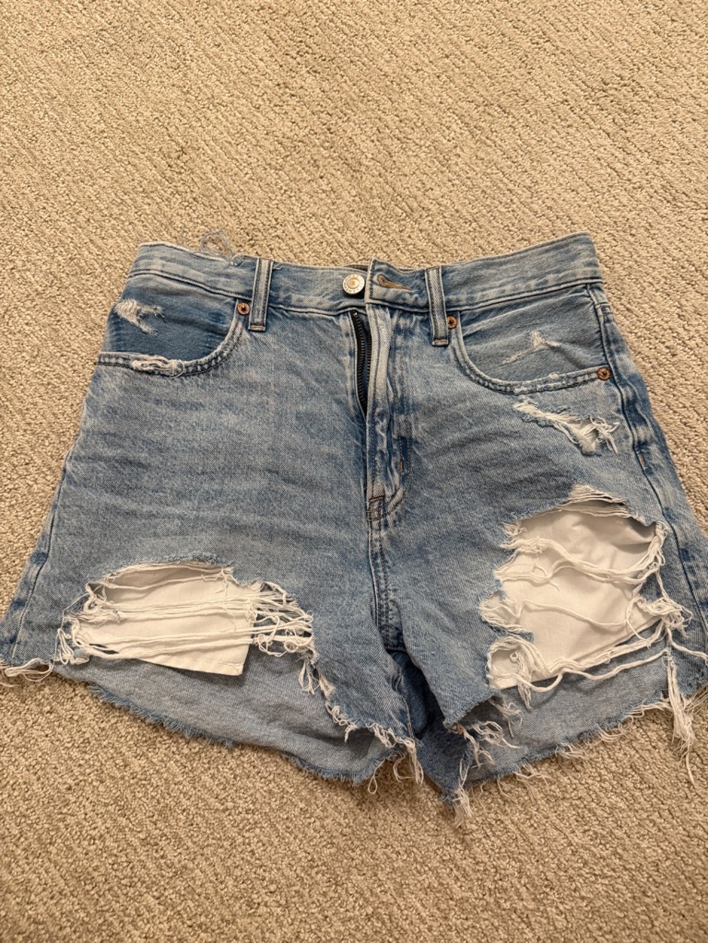 High-Rise Distressed Denim Shorts in Light Blue